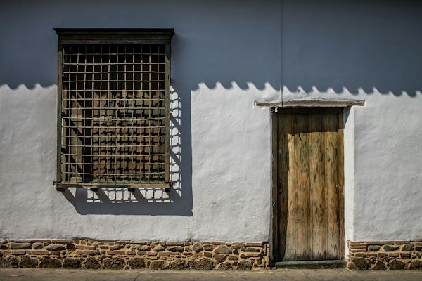 Traditional wooden window and white wall illustrating the architecture of historic towns near Medellín